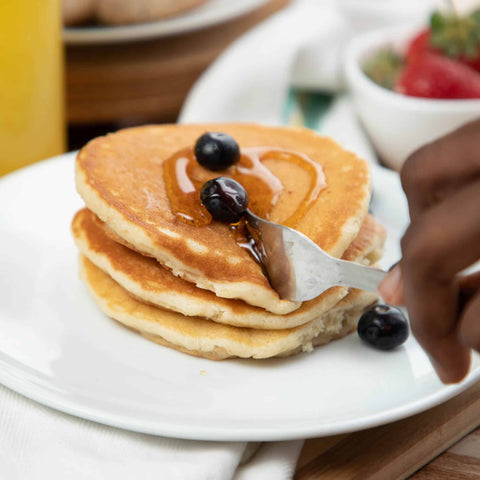 Pancakes with blueberries and syrup on a white plate - keto breakfast