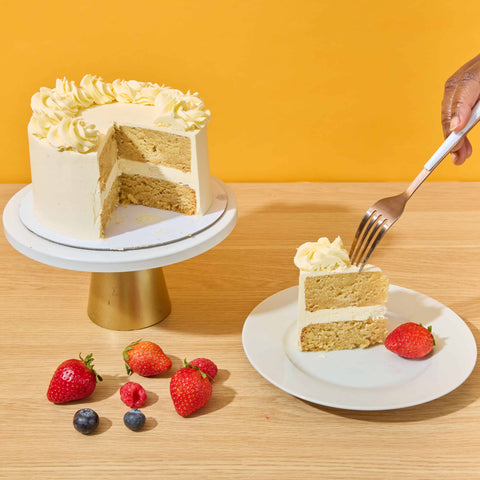 victoria sponge cake with a slice cut out and a fork digging into the slice