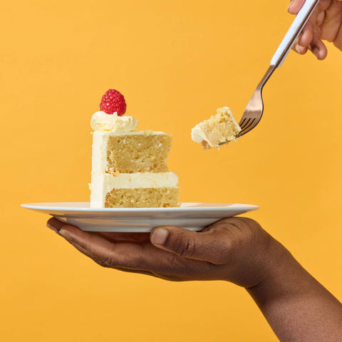 gluten free cake slice on a plate with a yellow background