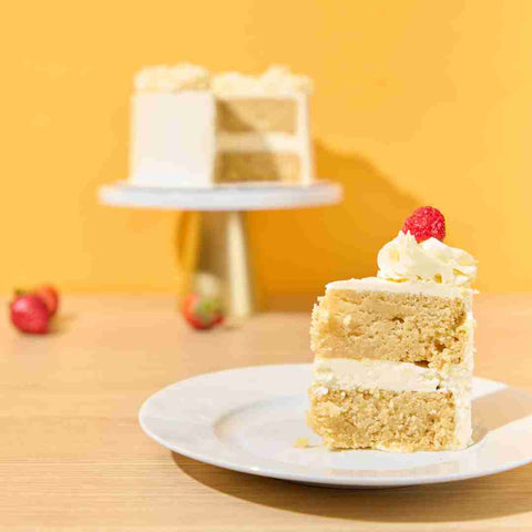 SLICE OF VANILLA KETO BIRTHDAY CAKE  WITH RASPBERRY ON TOP