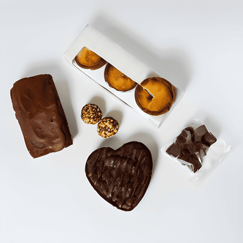 A Keto Share the Love Box of sugar-free treats and pastries on a white surface, perfect for a healthy lifestyle by No Guilt Bakes.