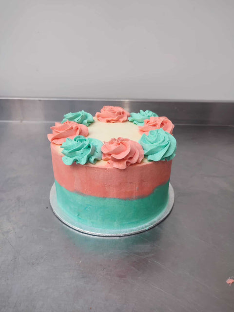 A Custom Made Low Sugar Cake from No Guilt Bakes decorated with pink, green and blue flowers.