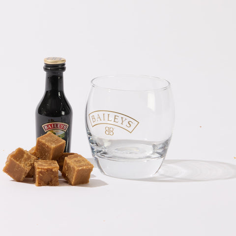 A guilt-free snack - a glass with a bottle of low-sugar No Guilt Bakes' Irish Cream Flavour Keto Fudge and some caramels, perfect for those on a keto fudge diet.