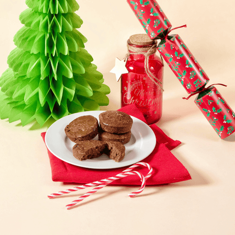 A plate of Sticky Toffee Keto Cake Bites by No Guilt Bakes next to a Christmas tree.